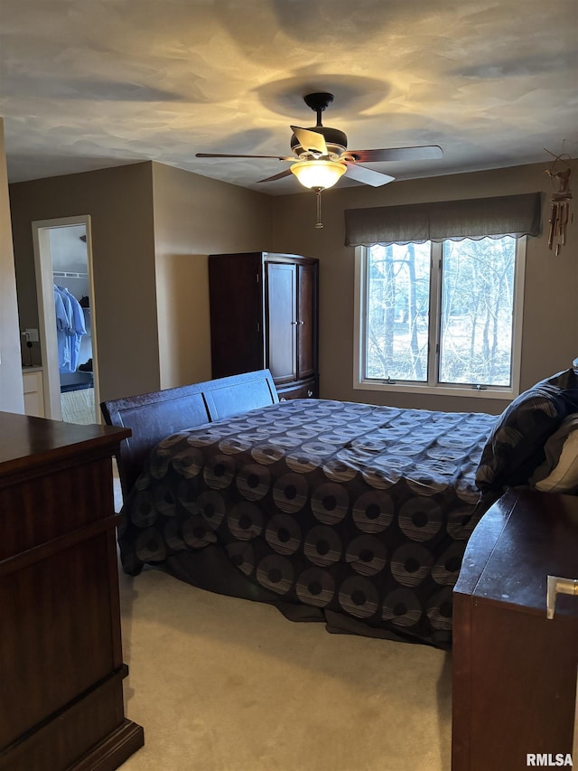 bedroom with a ceiling fan and light colored carpet