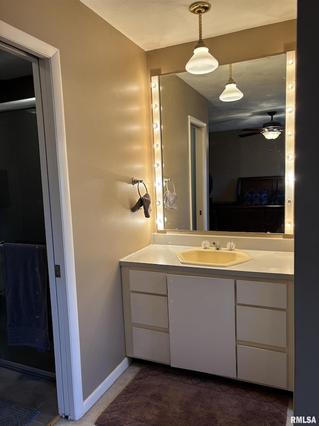 bathroom with ceiling fan, baseboards, and vanity