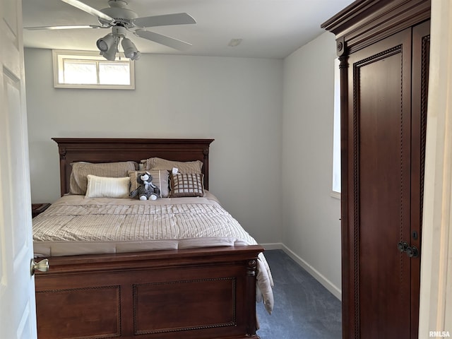 carpeted bedroom with ceiling fan and baseboards