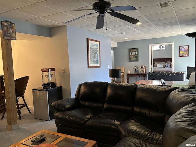 living area with light carpet, ceiling fan, visible vents, and a paneled ceiling