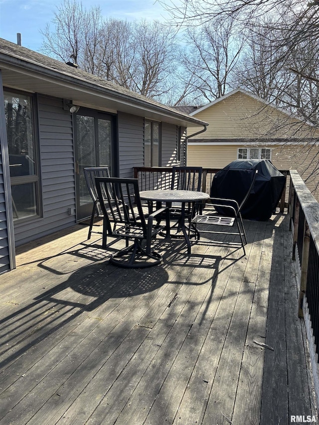 wooden terrace featuring outdoor dining space and area for grilling