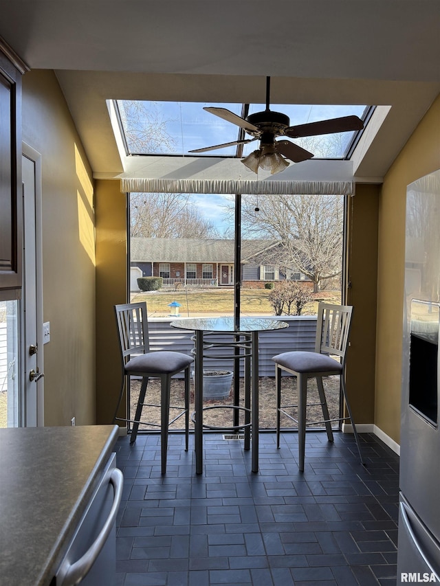 sunroom with a skylight and ceiling fan