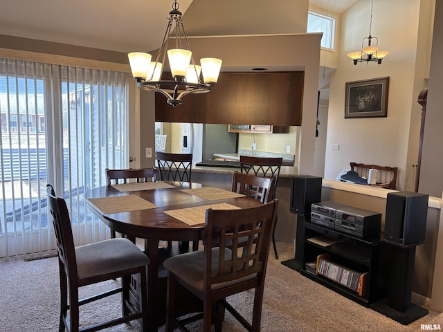 carpeted dining room featuring a chandelier