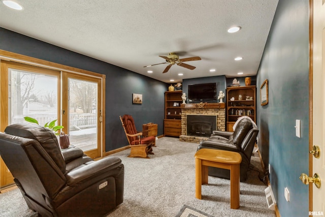 carpeted living room with a fireplace, recessed lighting, visible vents, a textured ceiling, and baseboards