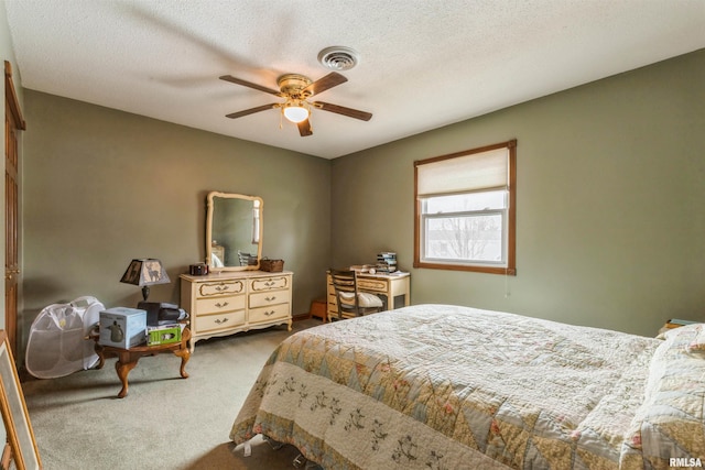 bedroom featuring a textured ceiling, carpet, visible vents, and a ceiling fan