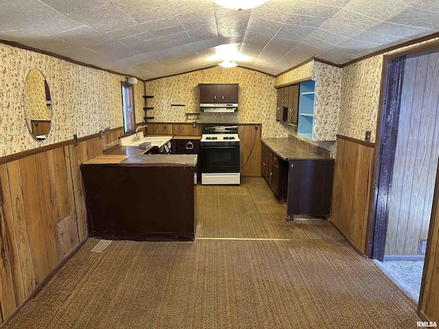 kitchen featuring gas range, wallpapered walls, and wainscoting