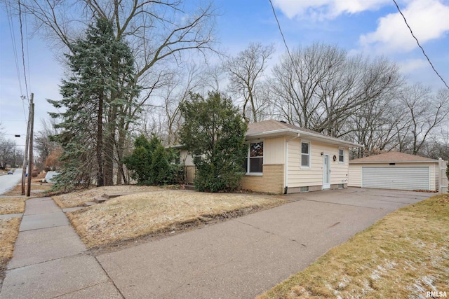 view of side of home featuring an outbuilding, brick siding, and a detached garage