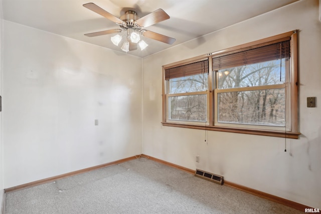 empty room with baseboards, visible vents, ceiling fan, and light colored carpet