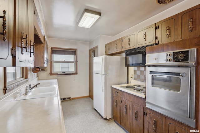 kitchen featuring light countertops, visible vents, backsplash, appliances with stainless steel finishes, and a sink