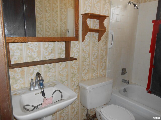 full bath featuring bathtub / shower combination, a sink, toilet, and wallpapered walls