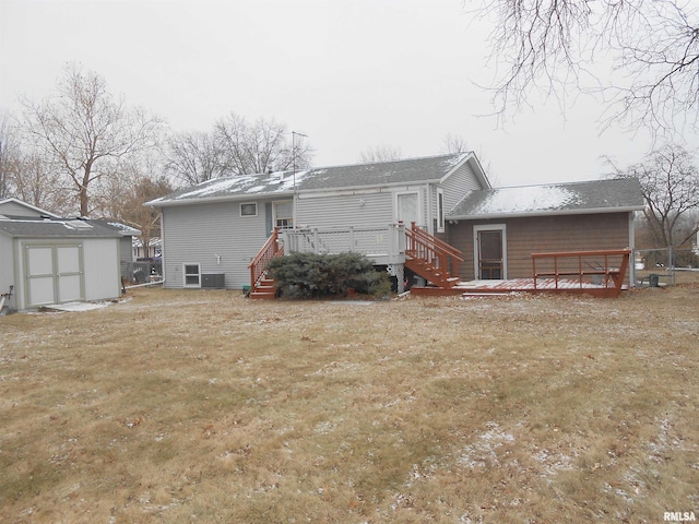 back of house featuring a storage shed, a yard, a deck, and an outdoor structure