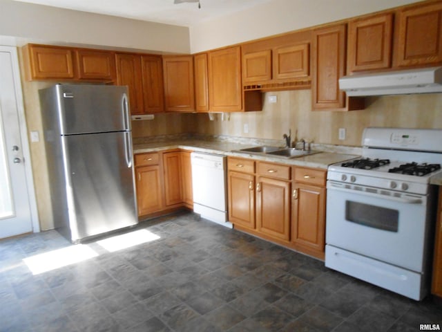 kitchen featuring light countertops, brown cabinetry, a sink, white appliances, and under cabinet range hood