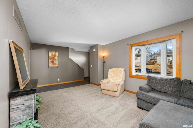 carpeted living area featuring a textured ceiling, visible vents, and baseboards