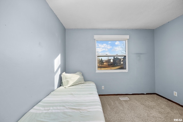 carpeted bedroom with visible vents and baseboards