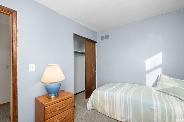 carpeted bedroom featuring visible vents and a closet