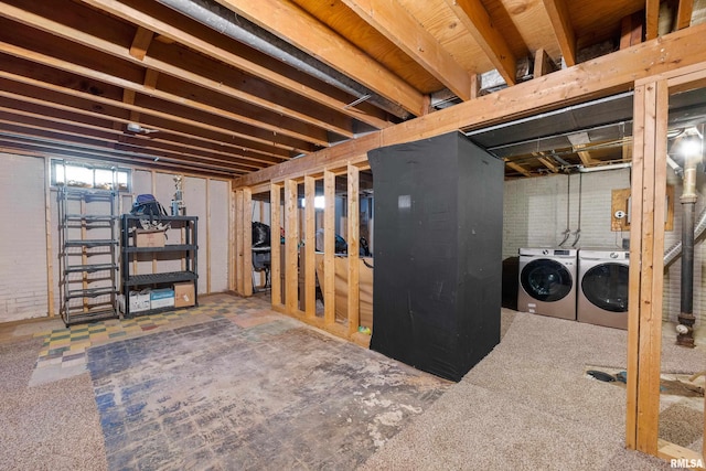 basement featuring washer and dryer and brick wall