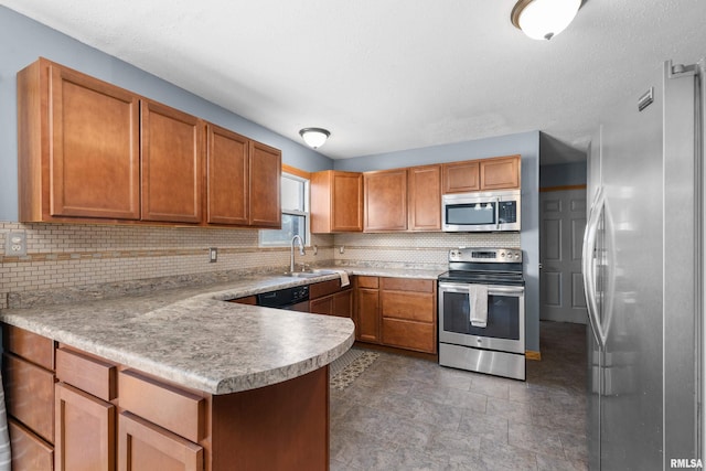 kitchen with stainless steel appliances, a peninsula, a sink, and decorative backsplash