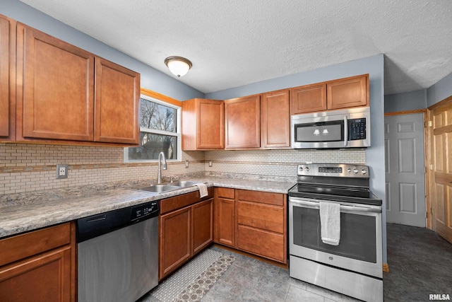 kitchen with brown cabinets, stainless steel appliances, tasteful backsplash, light countertops, and a sink