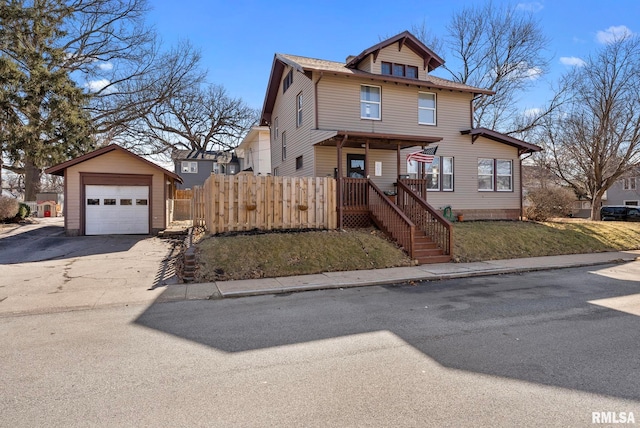 traditional style home featuring driveway, a detached garage, an outbuilding, fence, and a porch