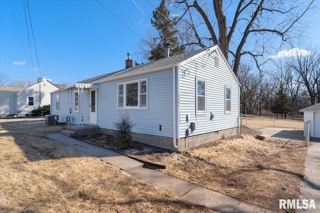 view of front of home featuring central AC, a chimney, and fence