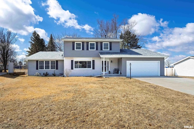 traditional-style house with a garage, concrete driveway, and a front yard