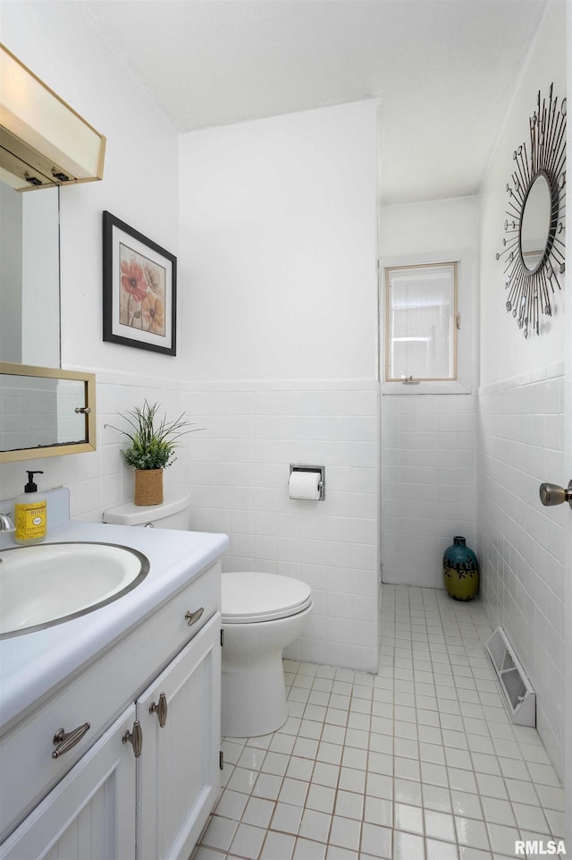 bathroom with toilet, tile patterned flooring, visible vents, and vanity