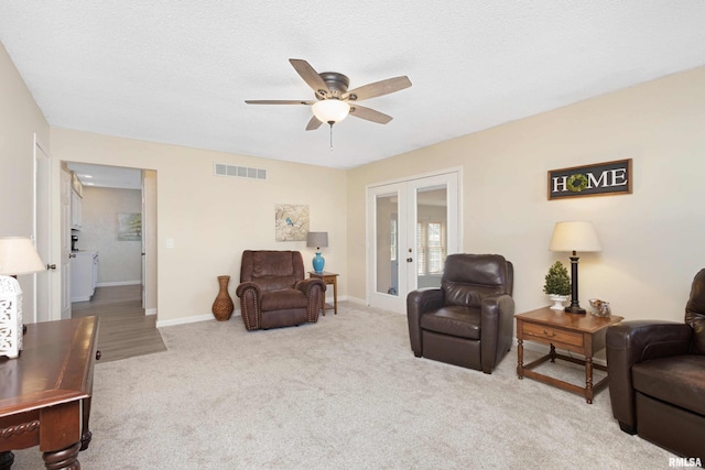 carpeted living room featuring ceiling fan, french doors, visible vents, and baseboards