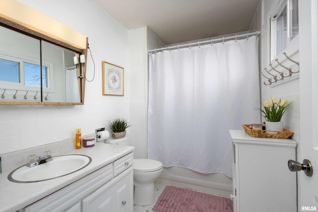 full bath with tile patterned flooring, toilet, vanity, tile walls, and shower / bath combo with shower curtain