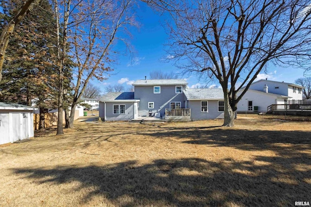 rear view of property with a deck and a yard