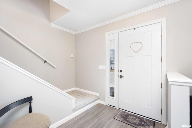 foyer featuring baseboards, stairway, crown molding, and wood finished floors