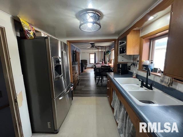 kitchen featuring a sink, a ceiling fan, stainless steel fridge with ice dispenser, brown cabinets, and light wood finished floors