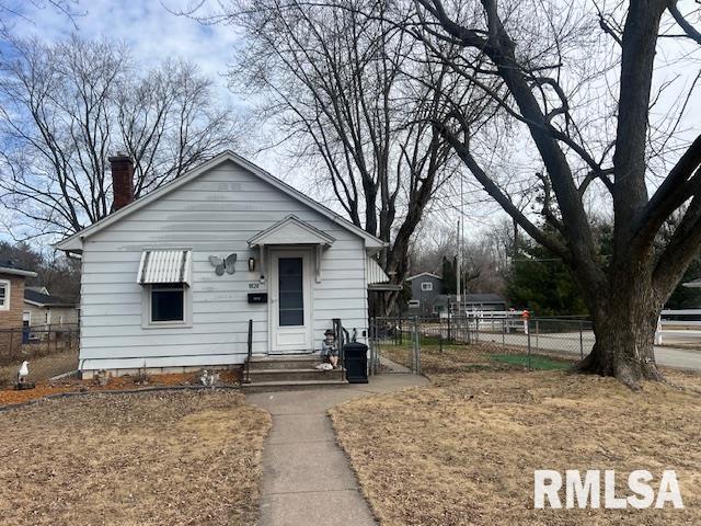 bungalow featuring a chimney and fence