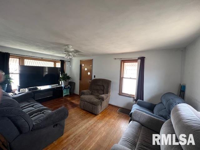 living area with wood finished floors and a ceiling fan