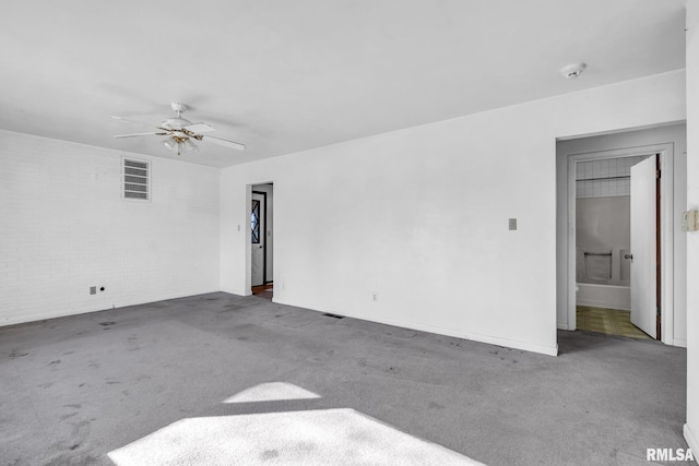 spare room with a ceiling fan and carpet