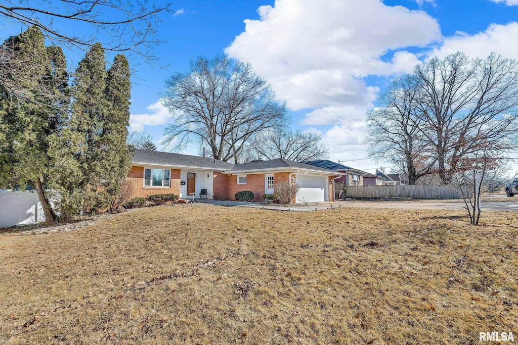 ranch-style home with a garage, driveway, brick siding, and fence