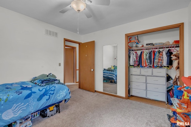 carpeted bedroom featuring a closet, visible vents, and ceiling fan