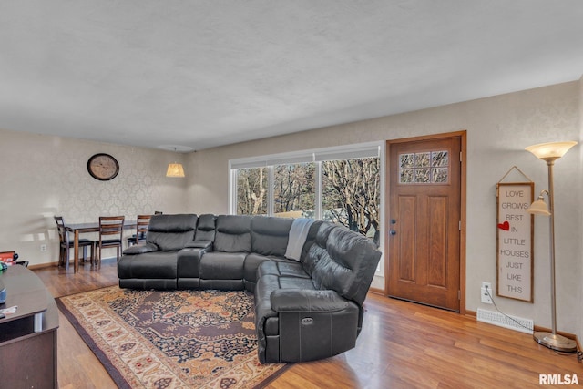 living area with visible vents, baseboards, and wood finished floors