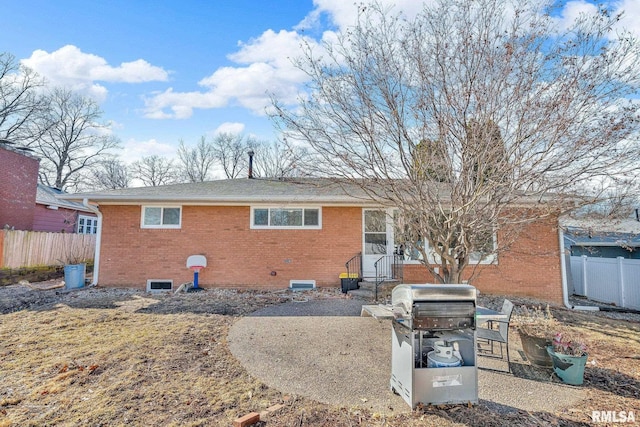 back of property featuring brick siding and fence