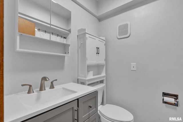 bathroom with visible vents, vanity, and toilet