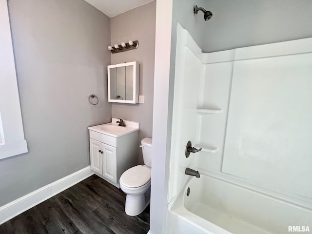 full bathroom featuring baseboards, toilet, wood finished floors, vanity, and shower / washtub combination