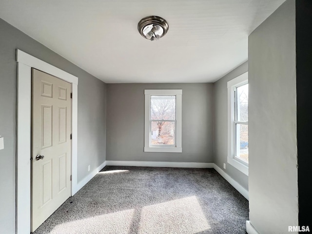 empty room featuring carpet flooring and baseboards