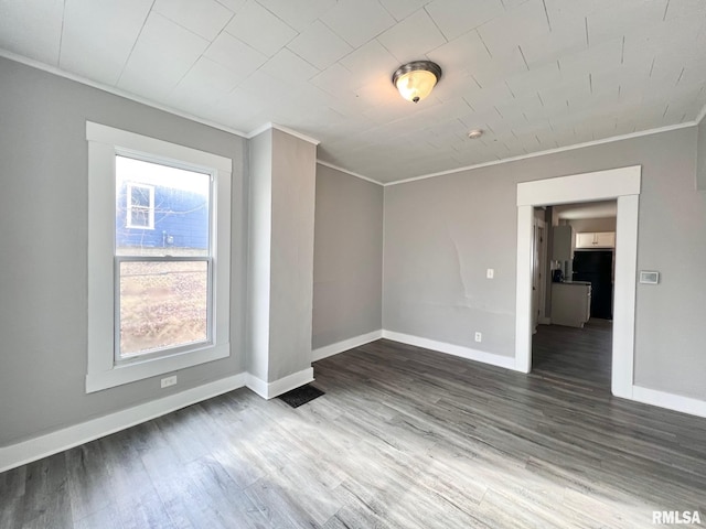 unfurnished bedroom featuring crown molding, baseboards, and wood finished floors