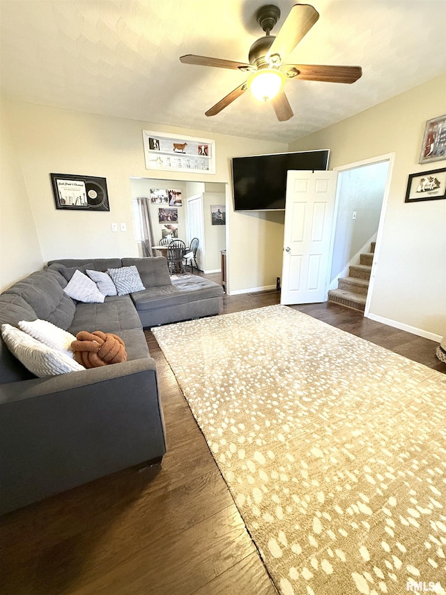 living area with stairway, baseboards, dark wood-style flooring, and ceiling fan