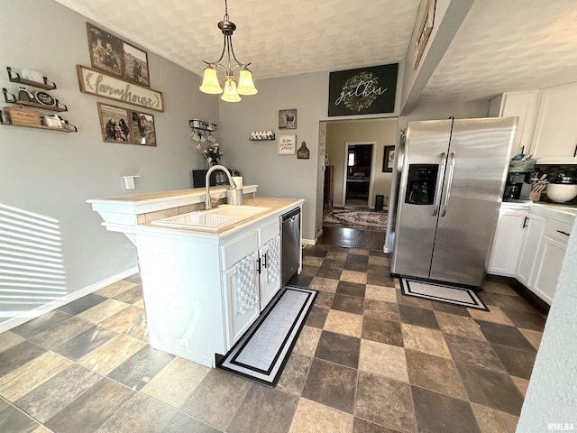 kitchen featuring a sink, appliances with stainless steel finishes, white cabinets, and light countertops