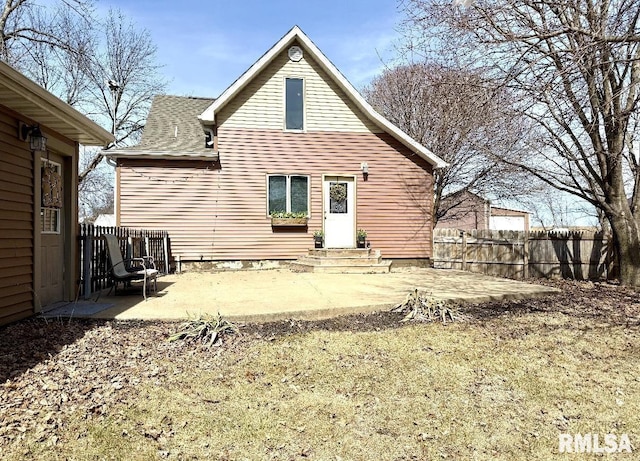 rear view of house featuring fence and a patio area