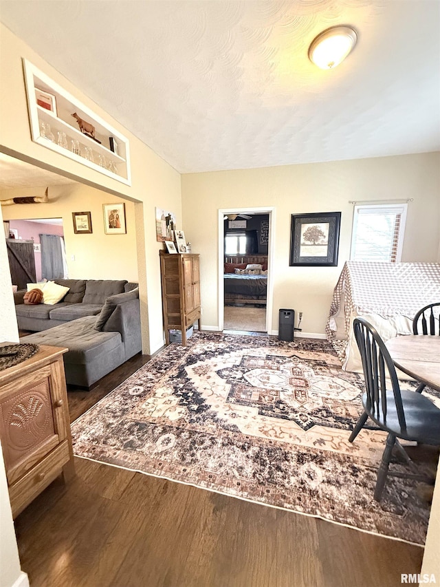 living area with baseboards and wood finished floors