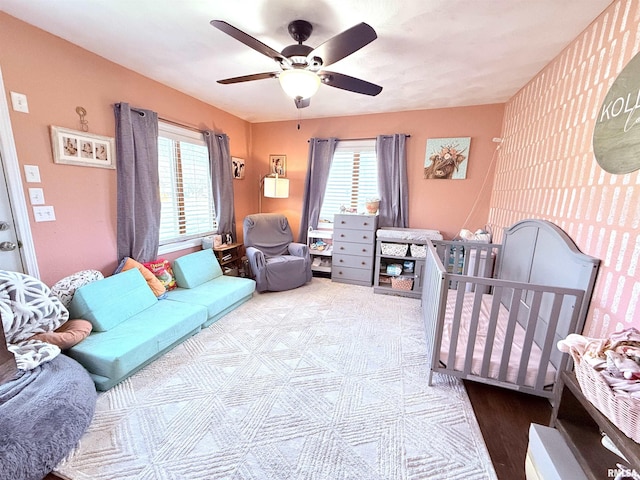 bedroom with wood finished floors, multiple windows, and ceiling fan