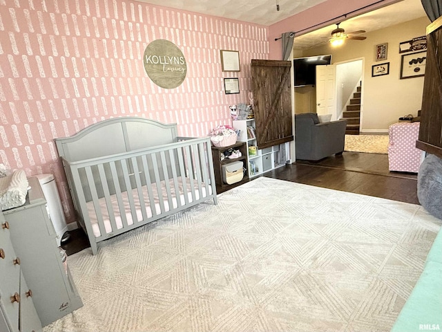 bedroom featuring wallpapered walls, wood finished floors, and baseboards