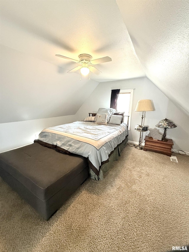 bedroom featuring baseboards, lofted ceiling, carpet flooring, a textured ceiling, and a ceiling fan