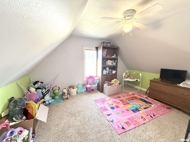 recreation room featuring a textured ceiling, ceiling fan, vaulted ceiling, and carpet